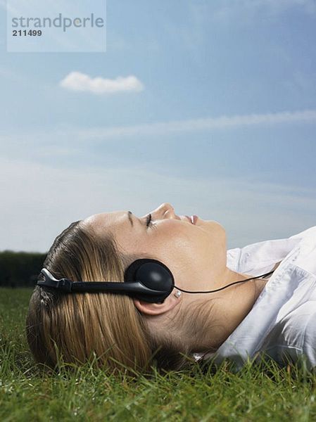 Frau beim Musikhören im Park