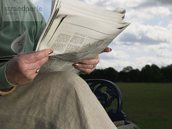 Ältere Frau beim Zeitungslesen