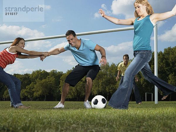 Freunde spielen Fußball im Park