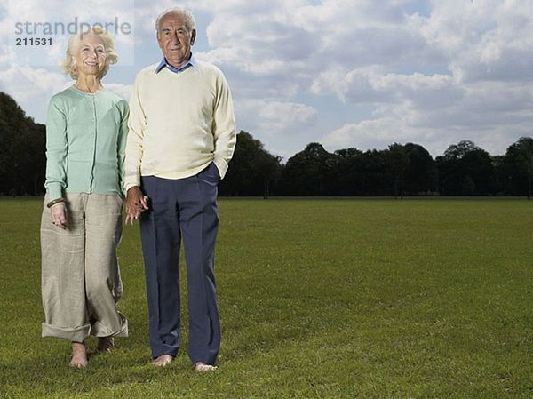 Älteres Ehepaar hält sich im Park an den Händen