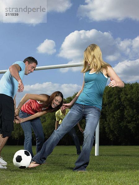 Freunde spielen Fußball im Park