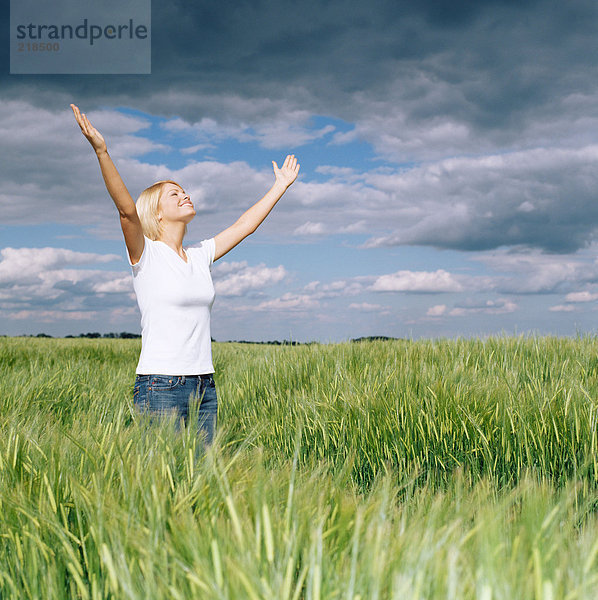 Frau mit offenen Armen im Feld