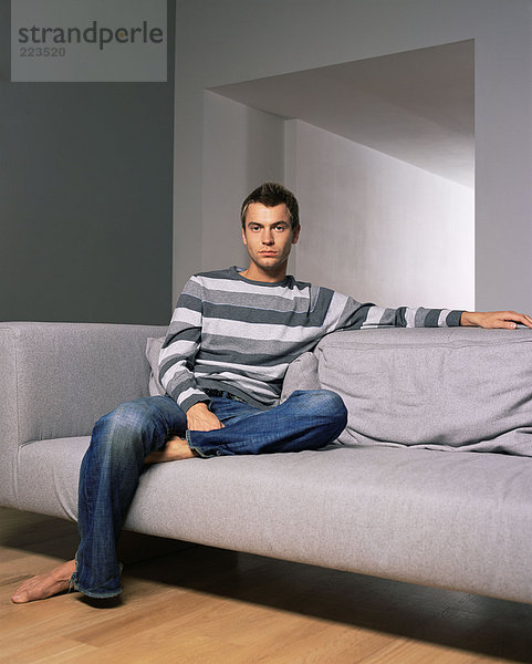 Junger Mann auf einem Sofa sitzend