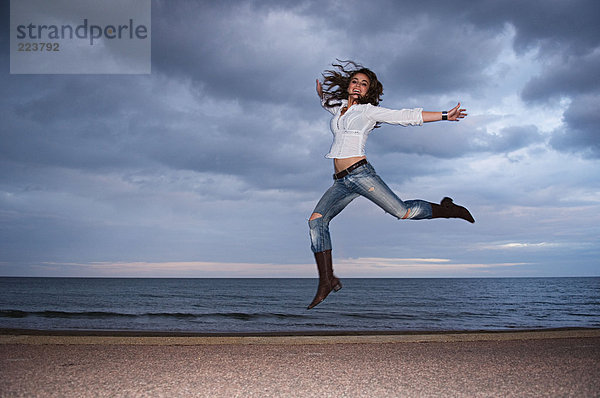 Frau beim Springen am Strand