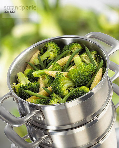 Broccoli  Maiskölbchen und grüne Bohnen im Dampftopf