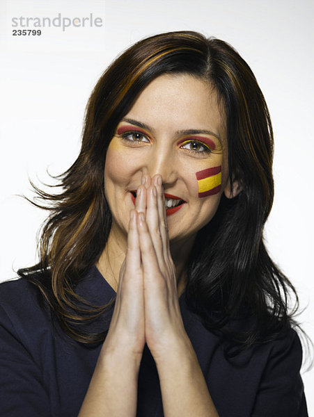Frau mit spanischer Flagge auf Gesicht gemalt  betend