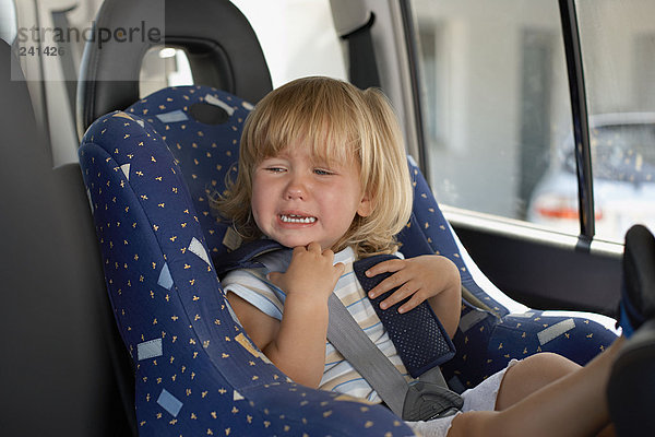 Junges Mädchen weint in ihrem Autositz