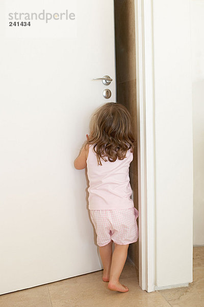 Junges Mädchen schiebt eine Tür auf