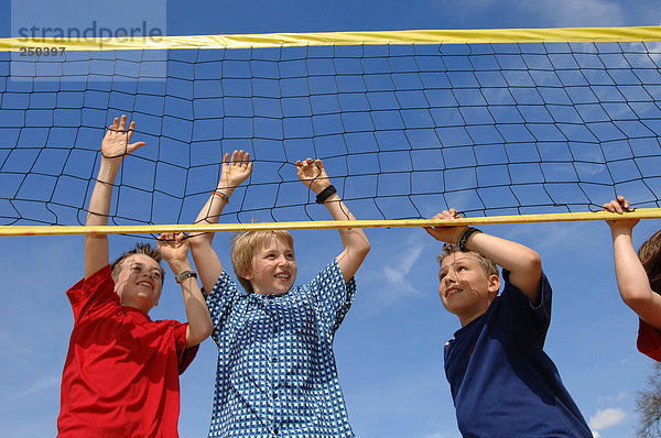 Jungen (6-9) am Volleyballnetz  Blickwinkel niedrig