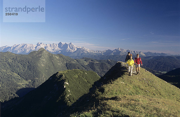 Austria  Salzburger Land  three people hiking in alps