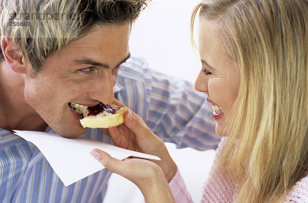 Frau füttert Mann Kuchen mit Marmelade  Nahaufnahme