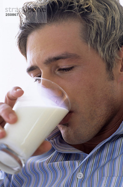 Junger Mann trinkt ein Glas Milch  Nahaufnahme