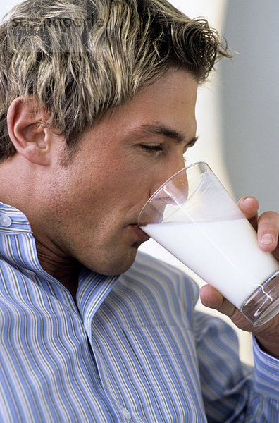 Junger Mann trinkt ein Glas Milch