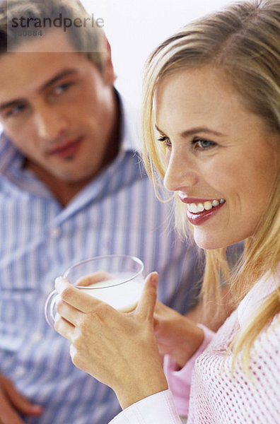 Junges Paar  Fokus auf Frau mit Milchglas