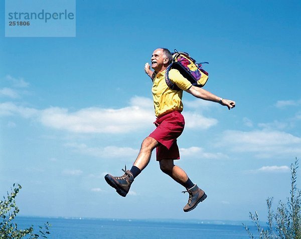 10422250  walking  Wandern  trekking  aktiv  Fitness  lachen  caper  springen  Senioren  Küste  Meer  See  Rucksack