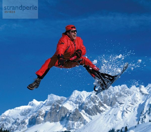 10453977  Wintersport  Sport  Gebirge  Mann  rote Skianzug  Ski  Schneemobil  Spaß  Witz  Sprung  Variationen  Varianten