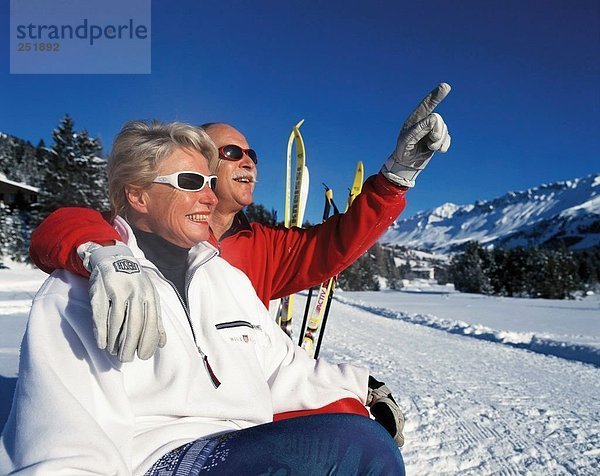 10494439  Wintersport  Sport  Winter  apres Ski  Mann  Punkt  Paar  Paar  Porträt  Rest  Senioren  Sit  Ski  Umarmung