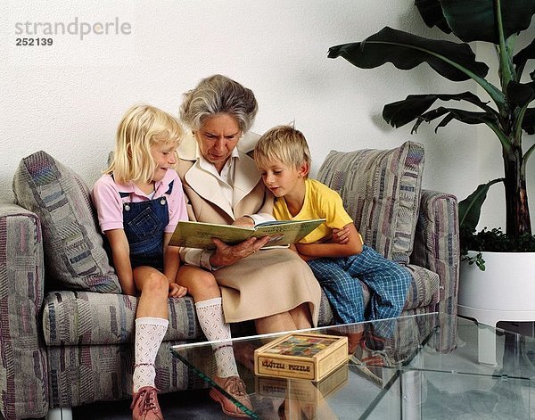 10007440  Buch  Familie  lesen  Enkel Enkelkinder  Großmutter  Großeltern  halb  spielen