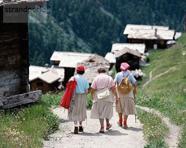 10016644  alpine  Alpen  Gebirge  Schweiz  Europa  aktiv  alte  Bergdorf  drei Frauen  Menschen  Rückansicht  Bosse