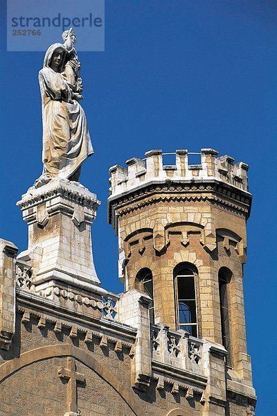 Jesus-Statue über Kirche gegen blauen Himmel