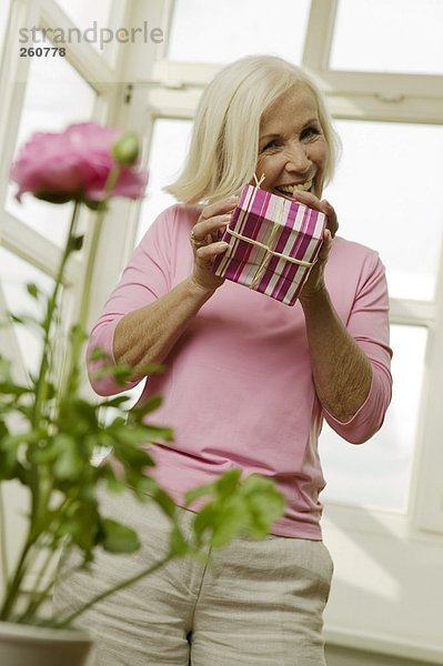 Seniorin mit Geschenkbox  lächelnd  Blickwinkel niedrig