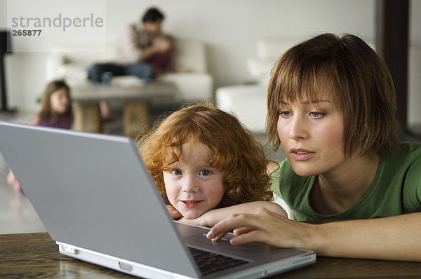 Frau und kleines Mädchen mit Computer