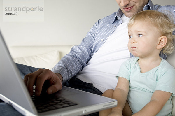 Mann und kleiner Junge mit Laptop