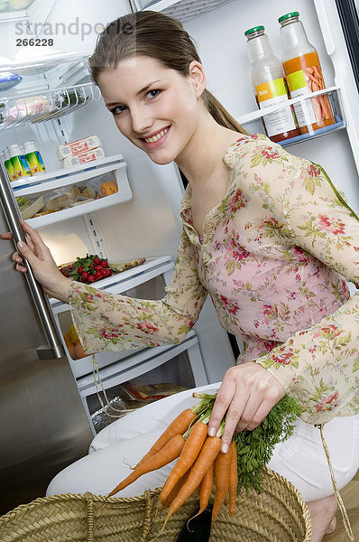 Frau vor dem Kühlschrank