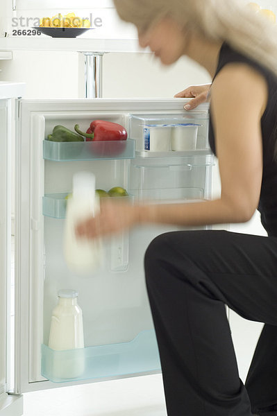 Frau sucht im Kühlschrank