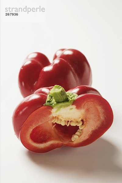 Zwei rote Tomatenpaprika  einer angeschnitten