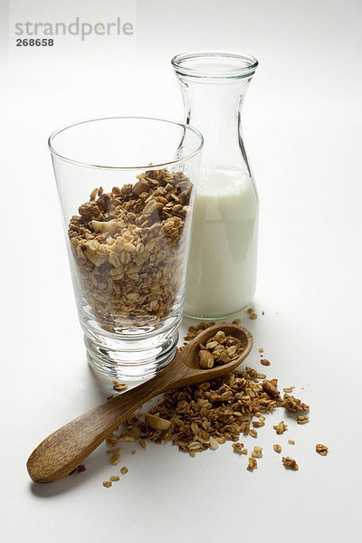 Knusper-Müsli in einem Glas  daneben Milchkaraffe (2)