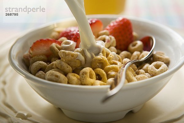 Cerealien in einer Schale werden mit Milch begossen (2)