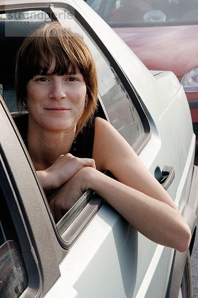 Eine Frau Blick durch ein Autofenster.