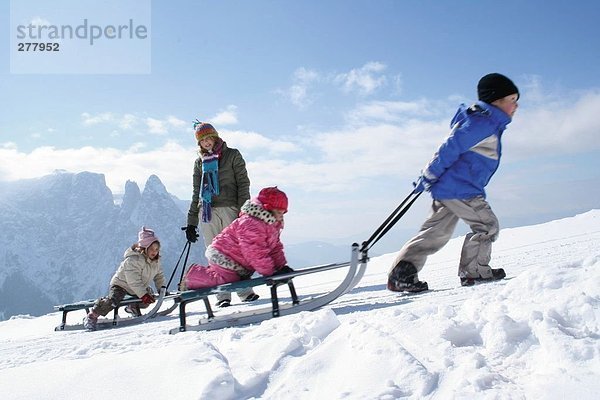 Frau mit ihren drei Kindern auf Schnee