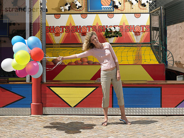 Frau hält Luftballons in der Hand