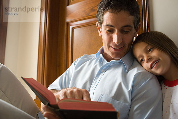 Vater liest Bibel mit Tochter