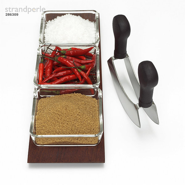 Rote Chilischoten  brauner Zucker und Salz auf Tablett  Nahaufnahme