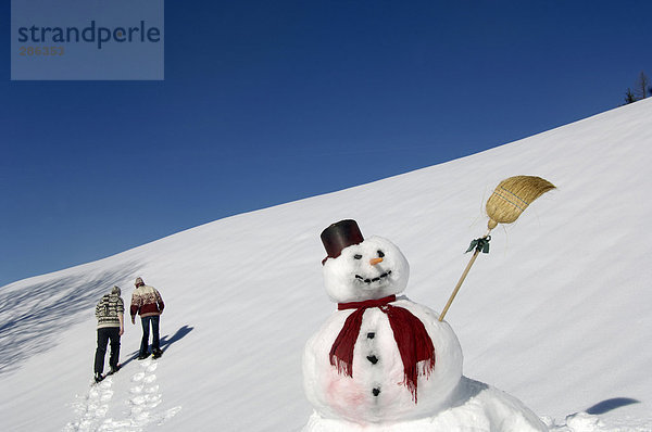 Schneemann  Paar im Hintergrund