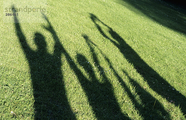 Menschliche Schatten auf Gras  Arme heben