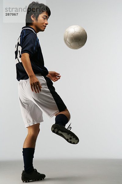 Fußball-Spieler jonglieren