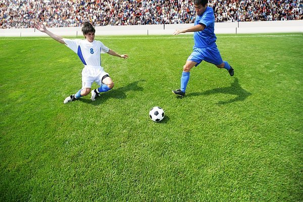 Fußball-Spieler treten Ball als Verteidiger Dias