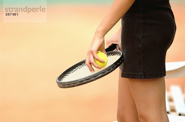 Nahaufnahme der weiblichen Spieler hält Tennisball