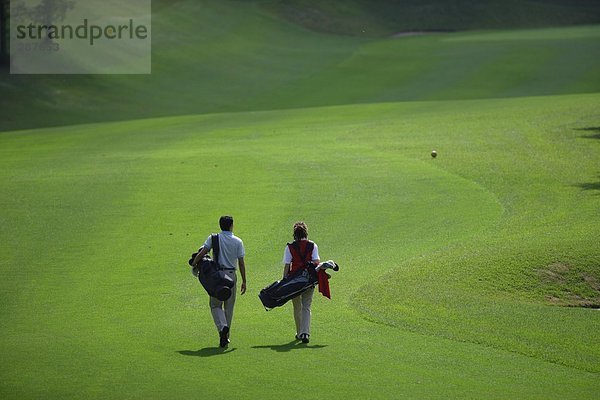 Paar geht hinunter Wiederschiffbarmachung der ein Golfplatz