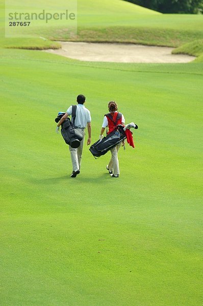 Paar geht hinunter Wiederschiffbarmachung der ein Golfplatz