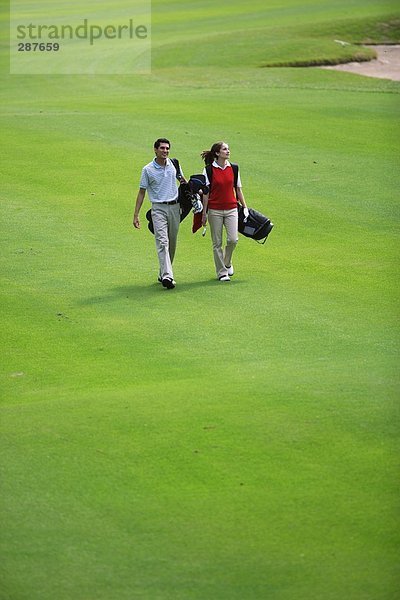 Paar geht hinunter Wiederschiffbarmachung der ein Golfplatz