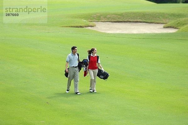 Paar geht hinunter Wiederschiffbarmachung der ein Golfplatz