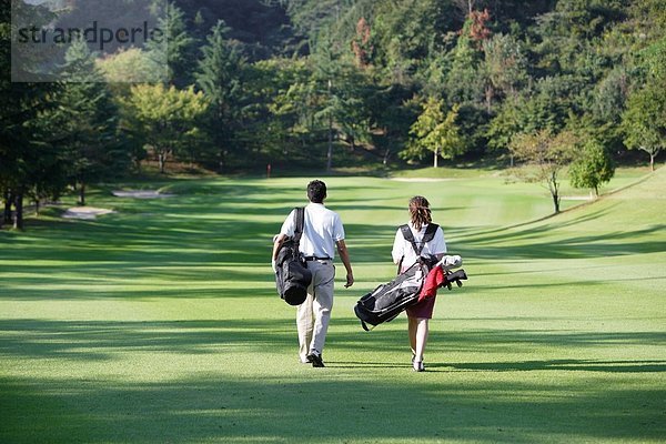 Paar geht hinunter Wiederschiffbarmachung der ein Golfplatz