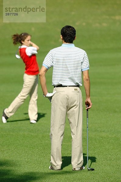 Mann gerade eine Frau eine Schüsse Golf spielen