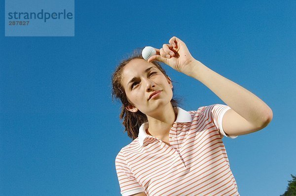 Frau schaut ein Golfball