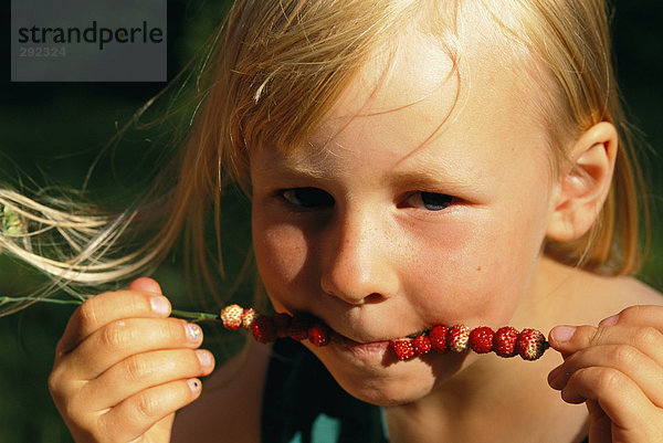Ein Mädchen  wilde Erdbeeren Essen.